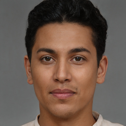 Joyful latino young-adult male with short  brown hair and brown eyes