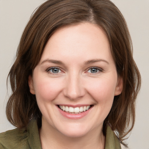 Joyful white young-adult female with medium  brown hair and grey eyes