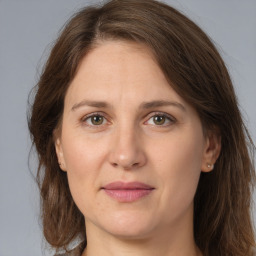 Joyful white adult female with long  brown hair and brown eyes