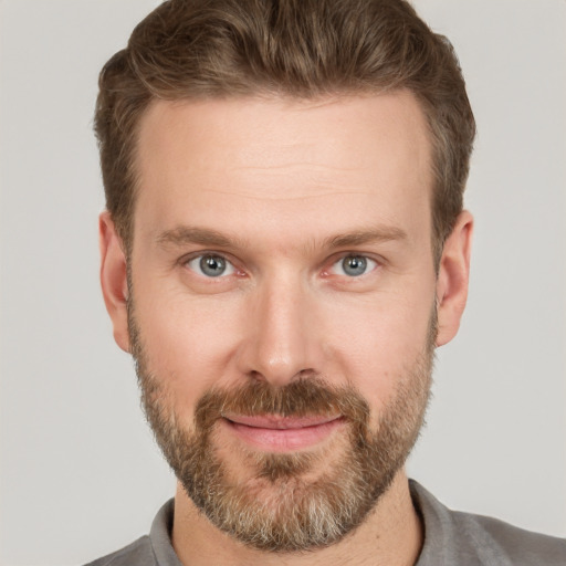 Joyful white adult male with short  brown hair and grey eyes