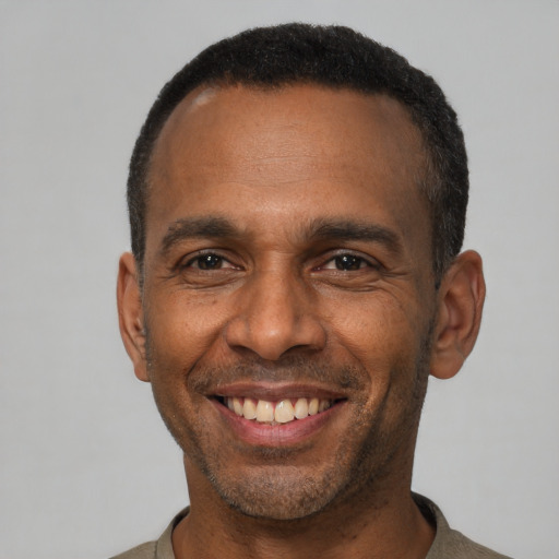 Joyful latino adult male with short  black hair and brown eyes