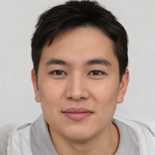 Joyful asian young-adult male with short  brown hair and brown eyes