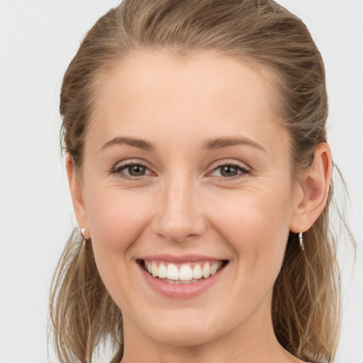 Joyful white young-adult female with long  brown hair and grey eyes