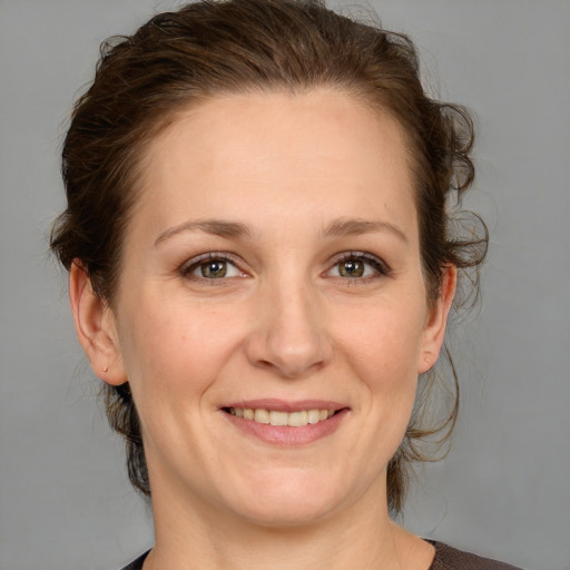 Joyful white adult female with medium  brown hair and grey eyes