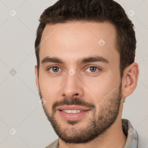 Joyful white young-adult male with short  brown hair and brown eyes