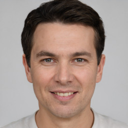 Joyful white adult male with short  brown hair and grey eyes