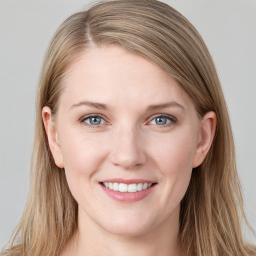 Joyful white young-adult female with long  brown hair and blue eyes