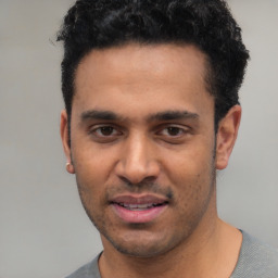 Joyful white young-adult male with short  black hair and brown eyes