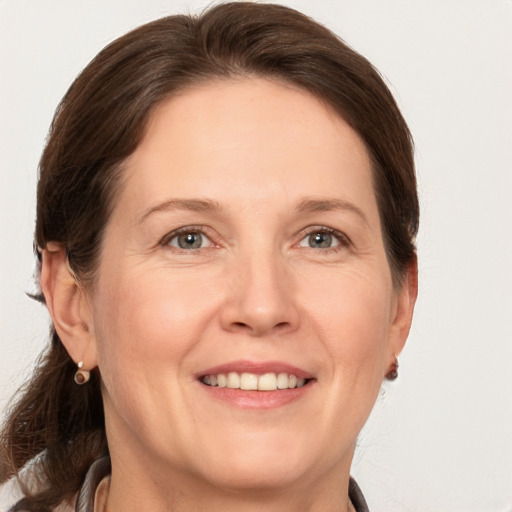 Joyful white adult female with medium  brown hair and grey eyes