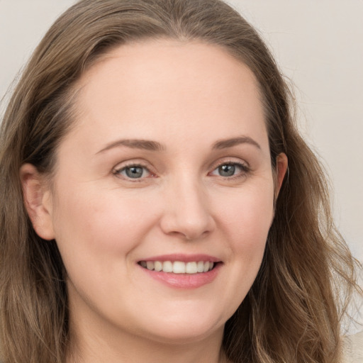 Joyful white young-adult female with long  brown hair and grey eyes