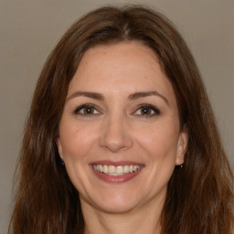 Joyful white adult female with long  brown hair and brown eyes