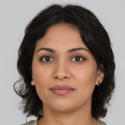 Joyful latino young-adult female with medium  brown hair and brown eyes