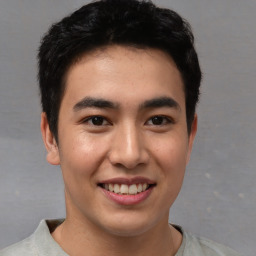 Joyful asian young-adult male with short  brown hair and brown eyes