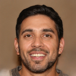 Joyful white adult male with short  black hair and brown eyes