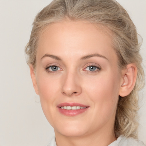 Joyful white young-adult female with medium  brown hair and blue eyes