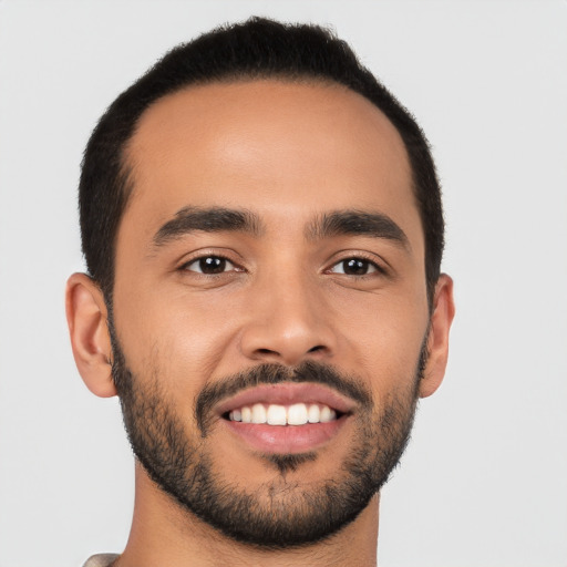 Joyful latino young-adult male with short  black hair and brown eyes