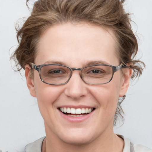 Joyful white adult female with short  brown hair and blue eyes