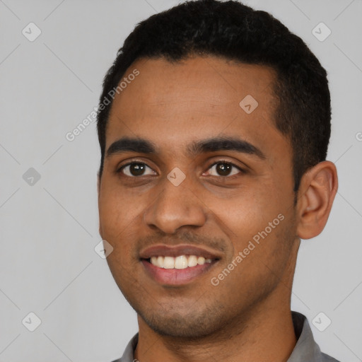 Joyful black young-adult male with short  black hair and brown eyes