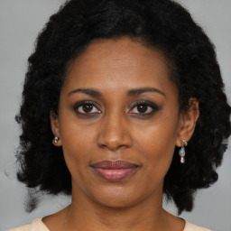 Joyful black young-adult female with medium  black hair and brown eyes
