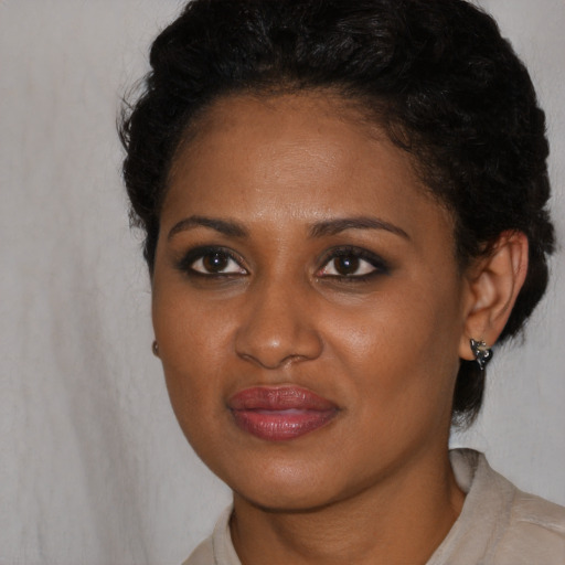 Joyful black young-adult female with short  black hair and brown eyes