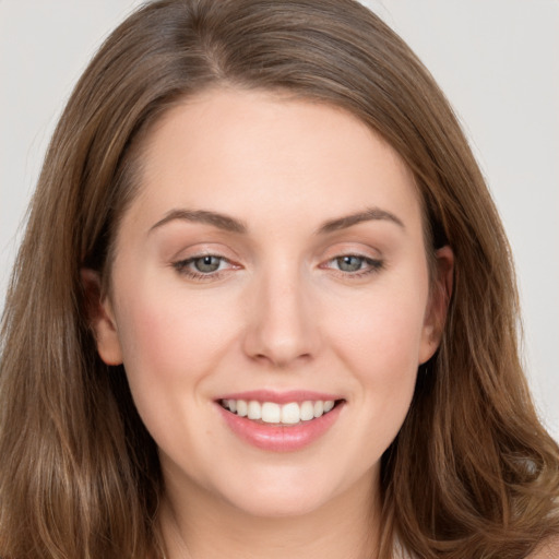 Joyful white young-adult female with long  brown hair and grey eyes