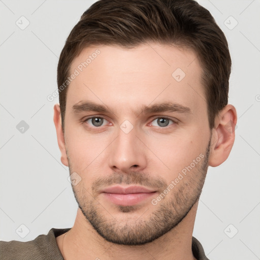 Joyful white young-adult male with short  brown hair and grey eyes