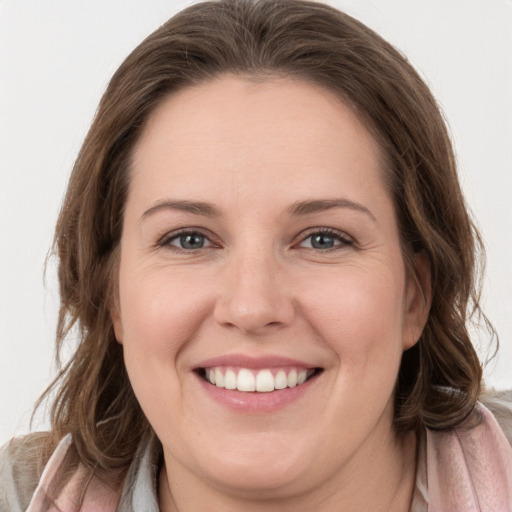 Joyful white young-adult female with long  brown hair and grey eyes