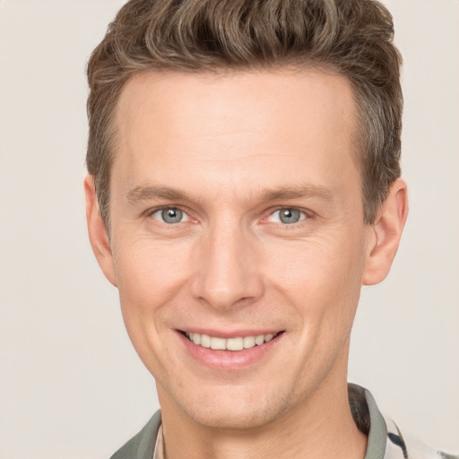 Joyful white adult male with short  brown hair and grey eyes