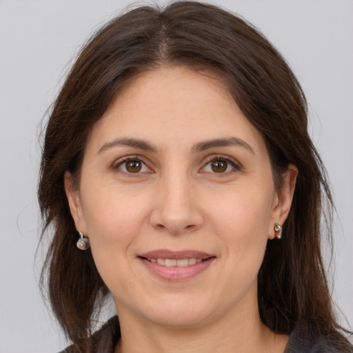 Joyful white adult female with long  brown hair and brown eyes