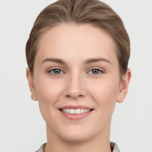 Joyful white young-adult female with short  brown hair and grey eyes