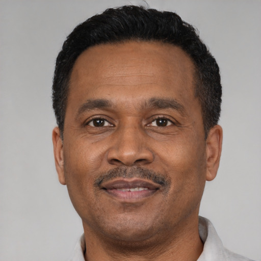 Joyful latino adult male with short  black hair and brown eyes