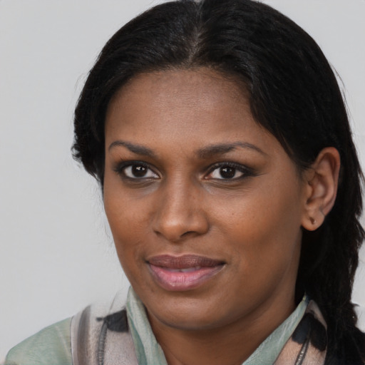 Joyful black young-adult female with long  brown hair and brown eyes