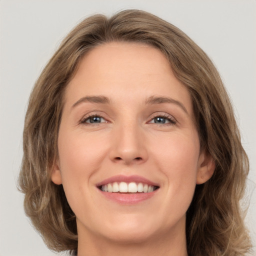 Joyful white young-adult female with medium  brown hair and green eyes