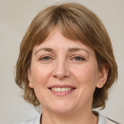 Joyful white adult female with medium  brown hair and grey eyes