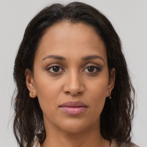 Joyful latino young-adult female with long  brown hair and brown eyes