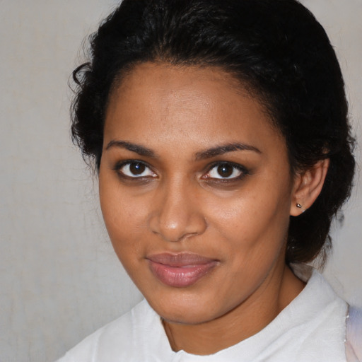 Joyful black young-adult female with medium  brown hair and brown eyes