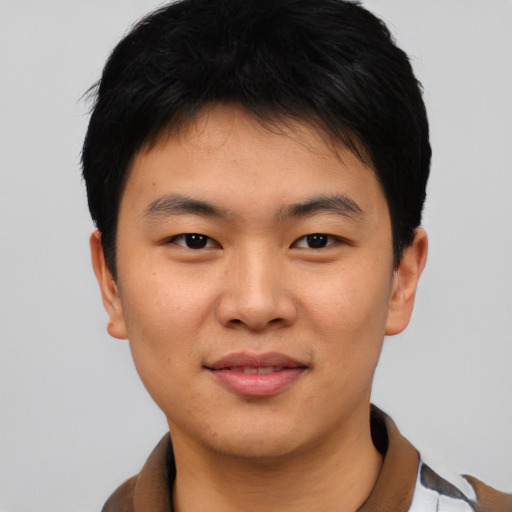 Joyful asian young-adult male with short  black hair and brown eyes