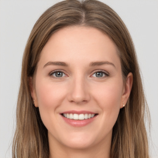 Joyful white young-adult female with long  brown hair and grey eyes