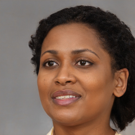 Joyful black young-adult female with medium  black hair and brown eyes