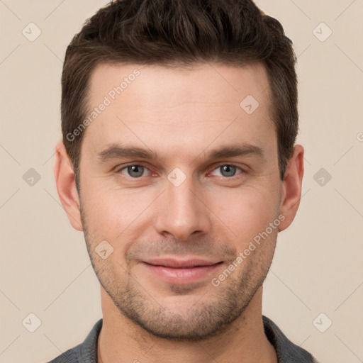 Joyful white young-adult male with short  brown hair and grey eyes