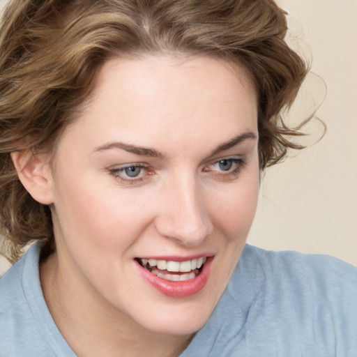 Joyful white young-adult female with medium  brown hair and blue eyes