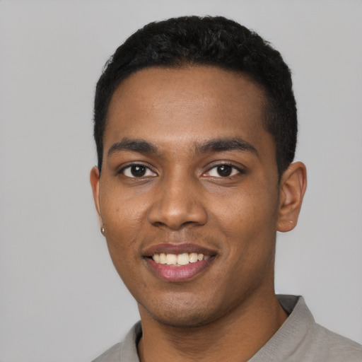 Joyful black young-adult male with short  black hair and brown eyes