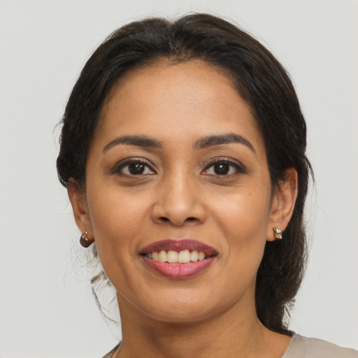 Joyful latino young-adult female with medium  brown hair and brown eyes