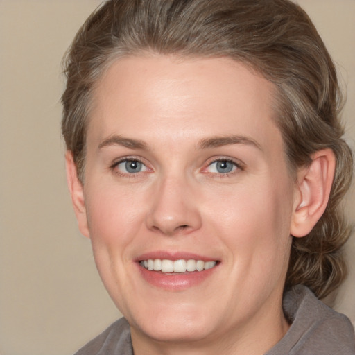 Joyful white adult female with medium  brown hair and grey eyes