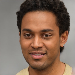 Joyful black young-adult male with short  brown hair and brown eyes