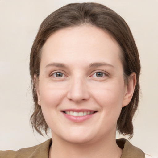 Joyful white young-adult female with medium  brown hair and grey eyes