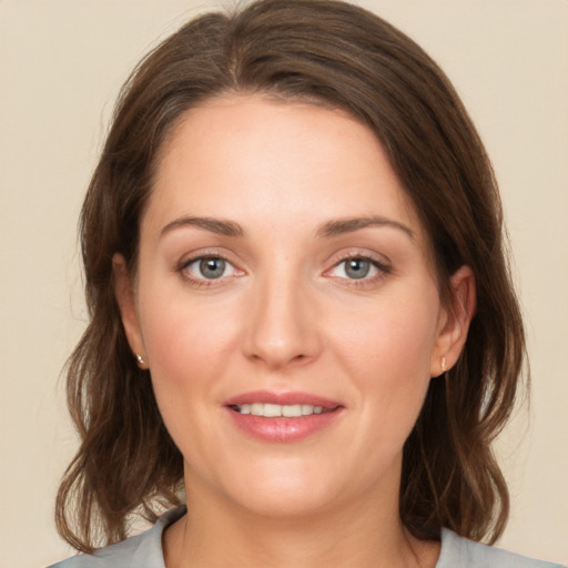 Joyful white young-adult female with medium  brown hair and green eyes