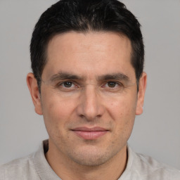 Joyful white adult male with short  black hair and brown eyes