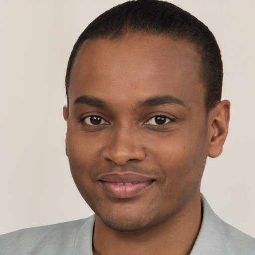 Joyful black young-adult male with short  black hair and brown eyes