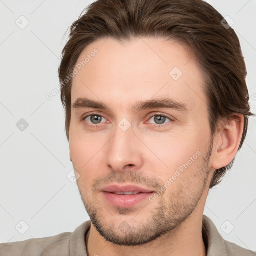 Joyful white young-adult male with short  brown hair and grey eyes